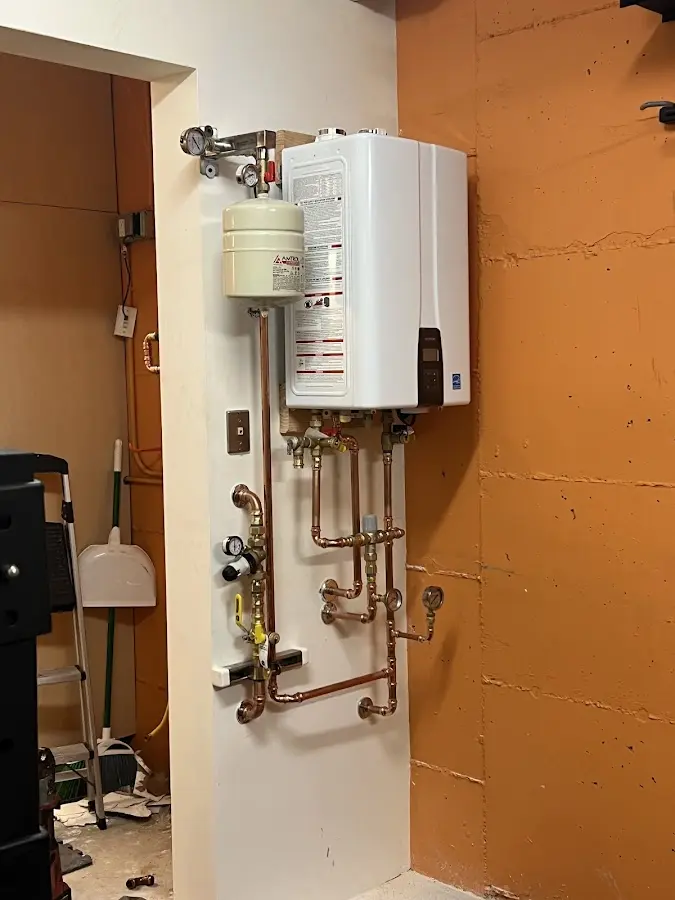 Plumbing technician inspecting water heater connections in Mojave